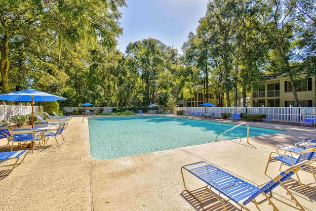 community pool featuring fence and a patio