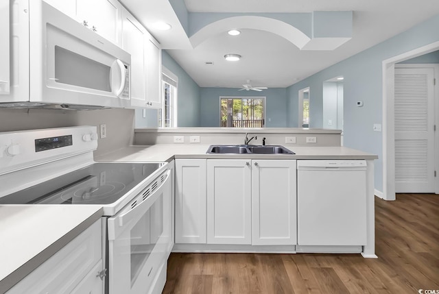 kitchen featuring white appliances, a sink, white cabinetry, a peninsula, and light countertops