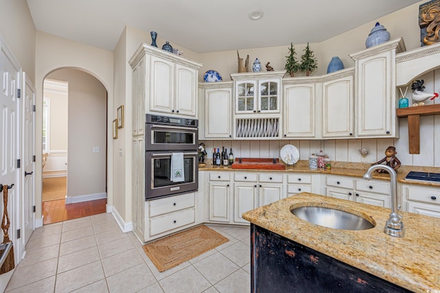 2278 Big Landing Dr, Little River, SC 29566 - kitchen with double oven, arched walkways, light tile patterned flooring, and a sink