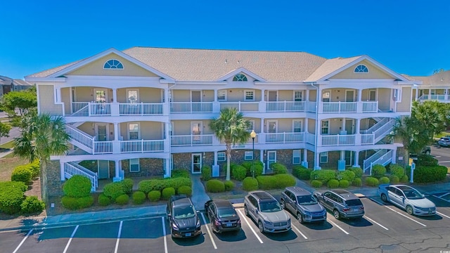 view of property with uncovered parking and stairway