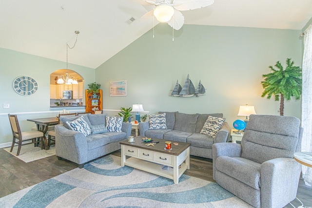 living area with arched walkways, visible vents, baseboards, ceiling fan with notable chandelier, and wood finished floors