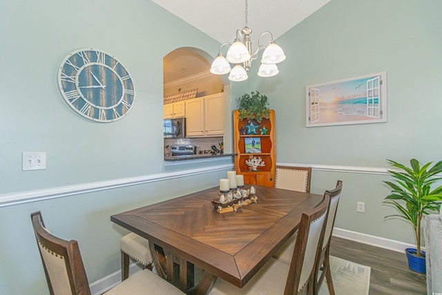 dining space with lofted ceiling, dark wood-type flooring, baseboards, and a chandelier