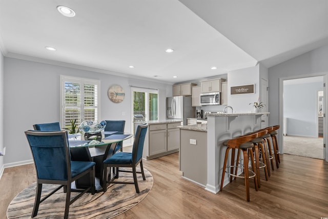 kitchen featuring crown molding, a peninsula, stainless steel appliances, and gray cabinetry