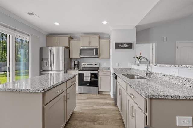 kitchen featuring visible vents, a sink, a peninsula, stainless steel appliances, and light wood-type flooring