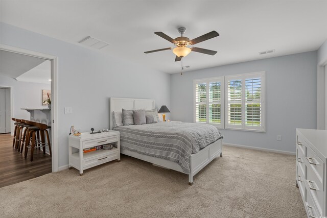 bedroom with light carpet, baseboards, a ceiling fan, and visible vents