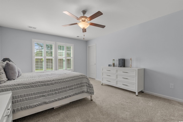 bedroom featuring a ceiling fan, baseboards, visible vents, and light colored carpet