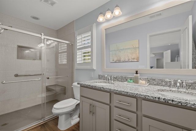 bathroom featuring a sink, toilet, visible vents, and wood finished floors