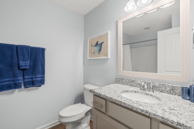 bathroom featuring toilet, curtained shower, and vanity