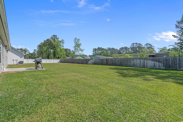 view of yard with central air condition unit, a patio, and a fenced backyard
