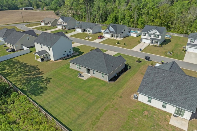 drone / aerial view with a wooded view and a residential view