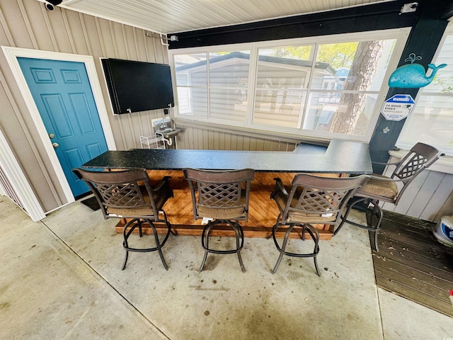 6001-1322 S Kings Hwy, Myrtle Beach, SC 29575 - dining area featuring plenty of natural light, concrete floors, and wood walls