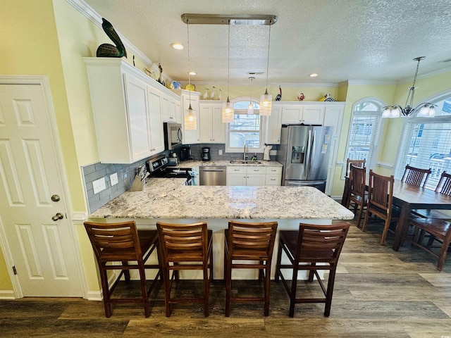 6001-1322 S Kings Hwy, Myrtle Beach, SC 29575 - kitchen with appliances with stainless steel finishes, a sink, a peninsula, healthy amount of natural light, and a textured ceiling
