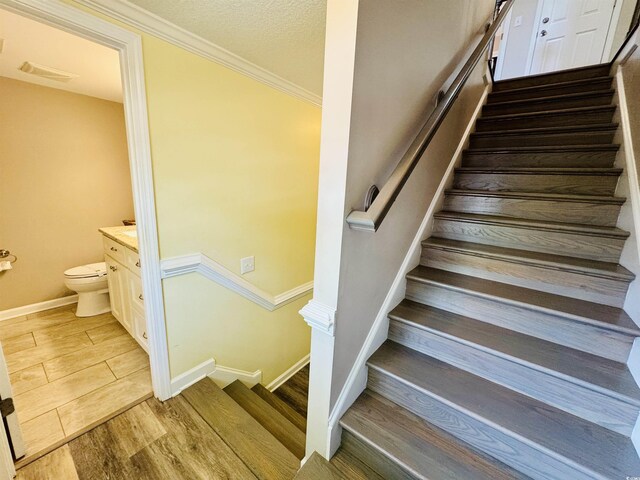 6001-1322 S Kings Hwy, Myrtle Beach, SC 29575 - stairway featuring baseboards, ornamental molding, and wood finished floors