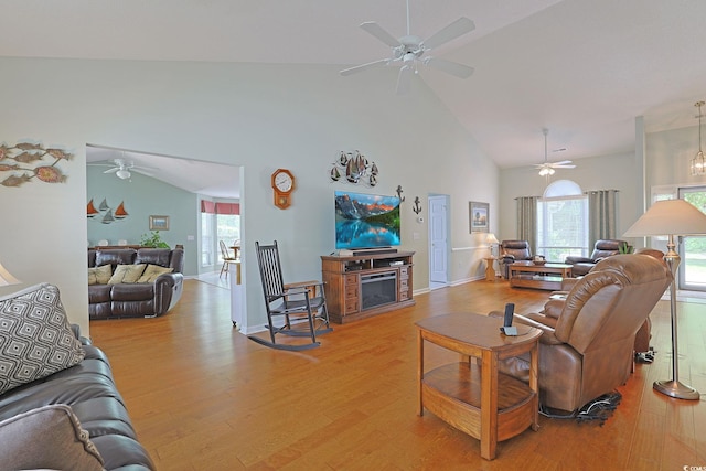 living room with high vaulted ceiling, baseboards, a ceiling fan, and light wood-style floors