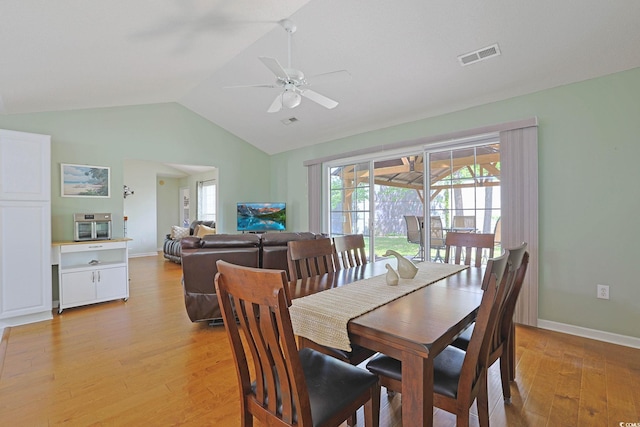 dining area featuring light wood-style floors, lofted ceiling, visible vents, and a wealth of natural light