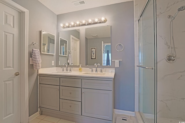 bathroom featuring visible vents, a sink, double vanity, and a stall shower