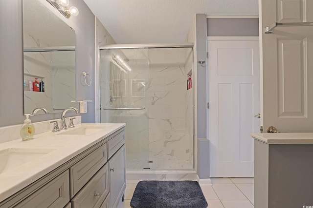 full bathroom with tile patterned floors, a sink, a shower stall, and double vanity