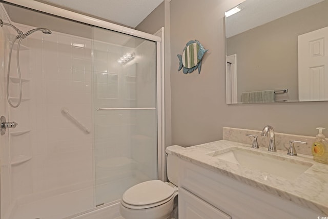 bathroom with a stall shower, vanity, and toilet