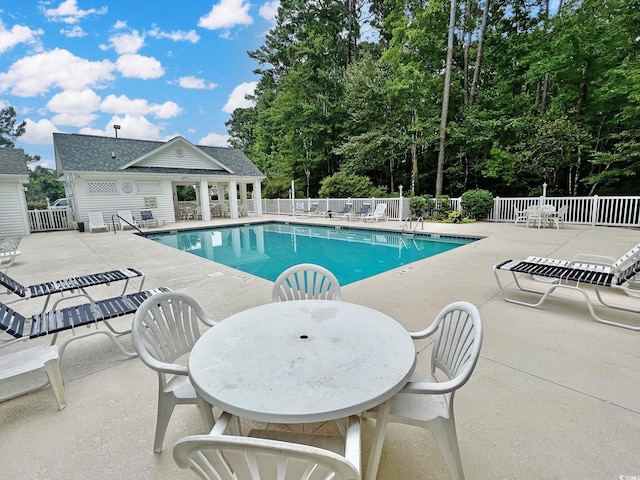 pool featuring fence and a patio area