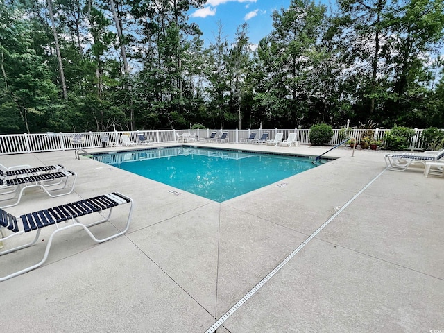 pool featuring fence and a patio
