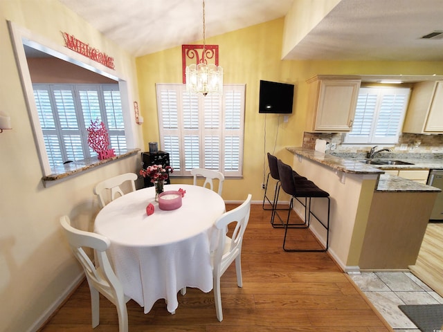 dining area featuring light wood-type flooring, baseboards, visible vents, and an inviting chandelier