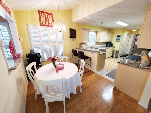 dining area with an inviting chandelier, visible vents, and light wood-style flooring