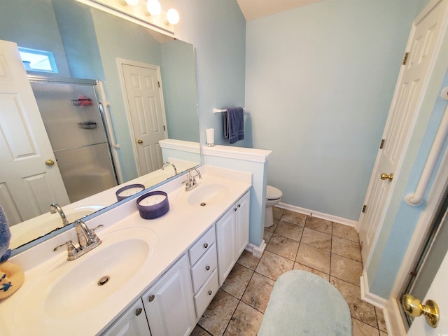 bathroom featuring a shower stall, toilet, a sink, and double vanity