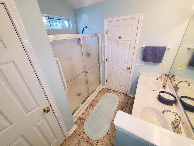 full bath with tile patterned flooring, a sink, and a stall shower