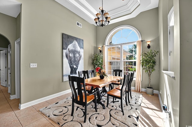 dining space featuring arched walkways, a chandelier, light tile patterned floors, ornamental molding, and visible vents