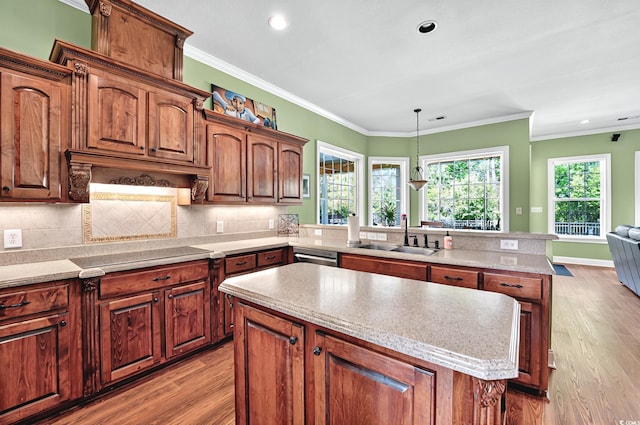 kitchen featuring a sink, black electric cooktop, a center island, a peninsula, and light wood-style flooring