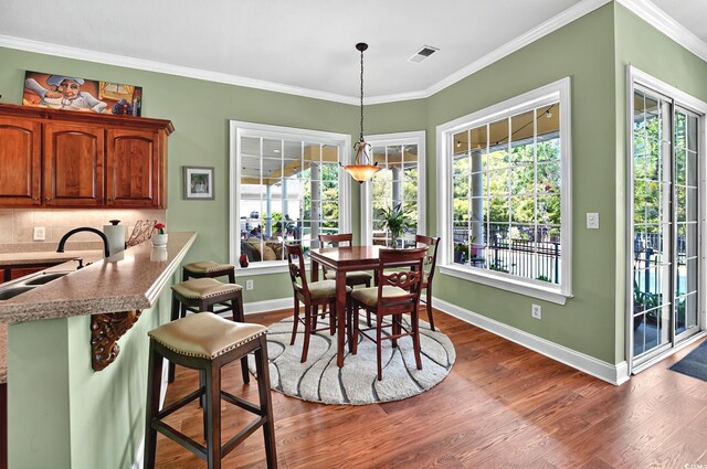 dining room featuring visible vents, plenty of natural light, dark wood finished floors, and baseboards