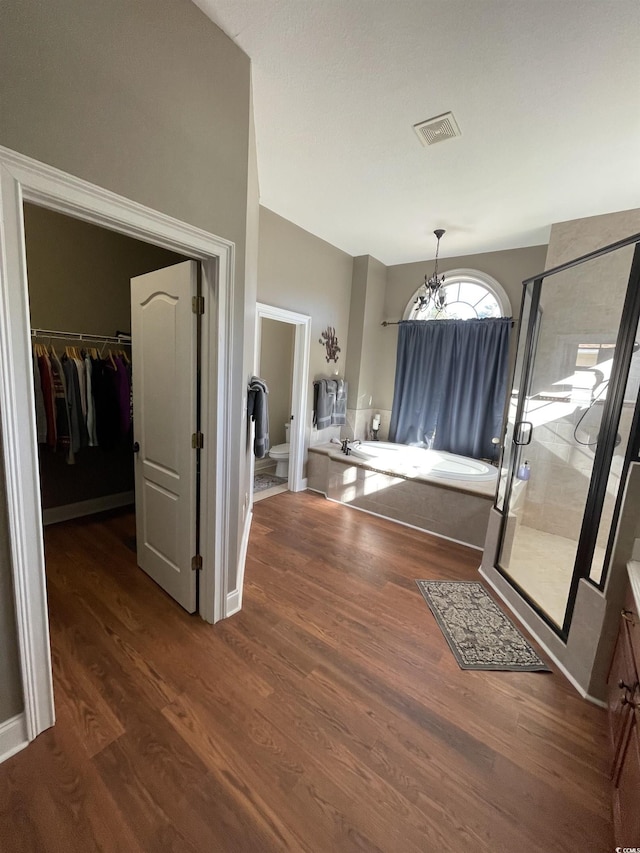 interior space with wood finished floors, visible vents, and a notable chandelier