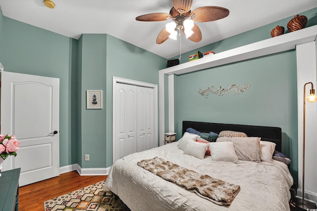 bedroom featuring a closet, a ceiling fan, wood finished floors, and baseboards