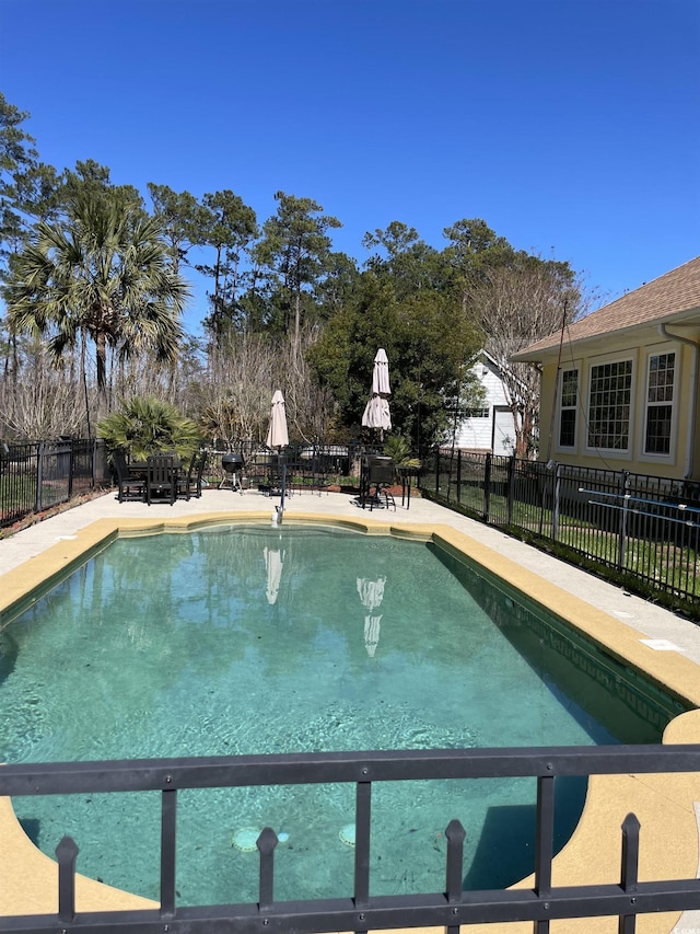 view of swimming pool featuring fence, a patio, and a fenced in pool