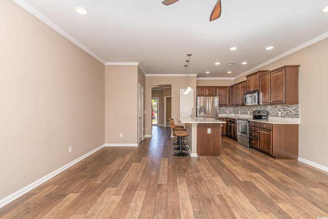 177 Olde Towne Way Unit 4, Myrtle Beach, SC 29588 - kitchen featuring appliances with stainless steel finishes, hardwood / wood-style floors, light countertops, an island with sink, and a breakfast bar area