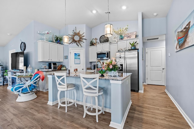 328 Logan St, Little River, SC 29566 - kitchen featuring light wood finished floors, stainless steel appliances, high vaulted ceiling, a center island with sink, and white cabinetry