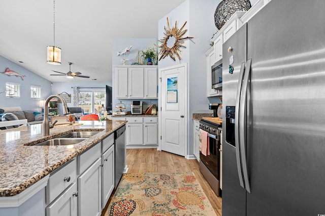 328 Logan St, Little River, SC 29566 - kitchen with white cabinets, a sink, appliances with stainless steel finishes, light wood-style floors, and open floor plan