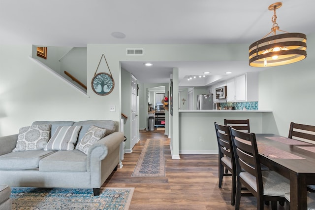 living room featuring recessed lighting, stairway, dark wood-style flooring, baseboards, and visible vents