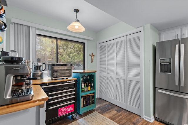 kitchen featuring dark wood-style floors, wood counters, stainless steel refrigerator with ice dispenser, a toaster, and hanging light fixtures