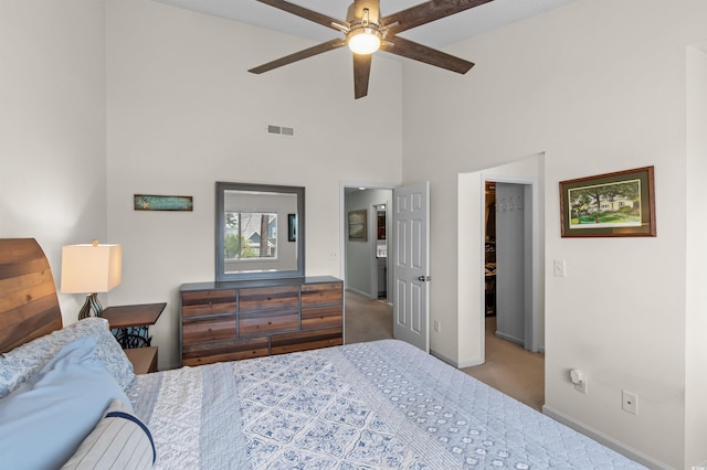 carpeted bedroom featuring a spacious closet, ceiling fan, baseboards, visible vents, and high vaulted ceiling