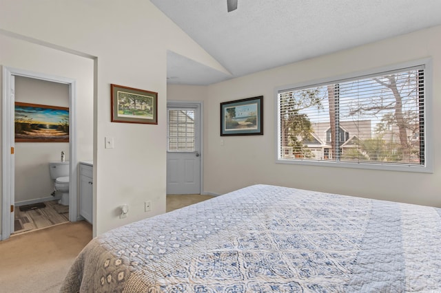 carpeted bedroom with connected bathroom, ceiling fan, and lofted ceiling