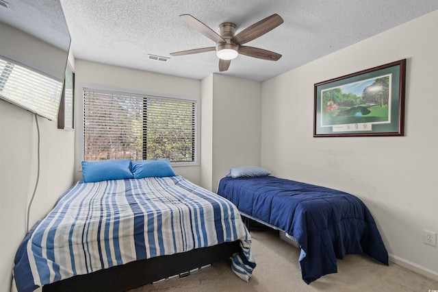 bedroom featuring ceiling fan, visible vents, carpet, baseboards, and a textured ceiling