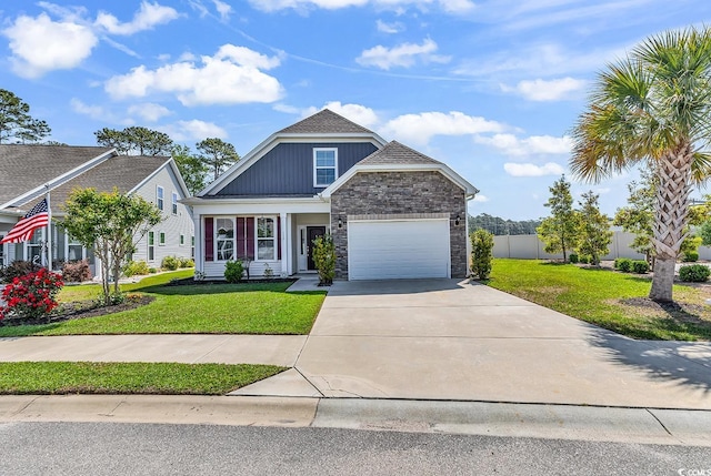 view of front of home with concrete driveway, a front lawn, stone siding, fence, and a garage