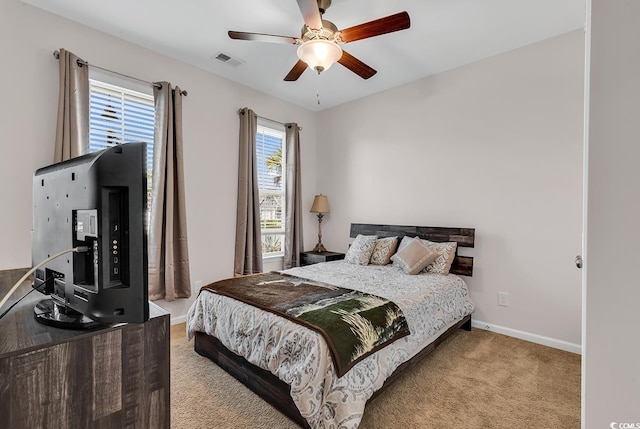 carpeted bedroom with baseboards, a ceiling fan, and visible vents