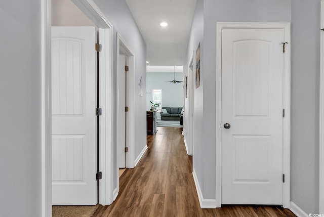 corridor with baseboards, recessed lighting, and dark wood finished floors