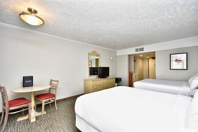 7100 N Ocean Blvd Unit 405, Myrtle Beach, SC 29572 - carpeted bedroom featuring a textured ceiling, crown molding, and baseboards