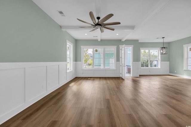 868 Crystal Water Way, Myrtle Beach, SC 29579 - unfurnished living room with a ceiling fan, beamed ceiling, wood finished floors, wainscoting, and a chandelier