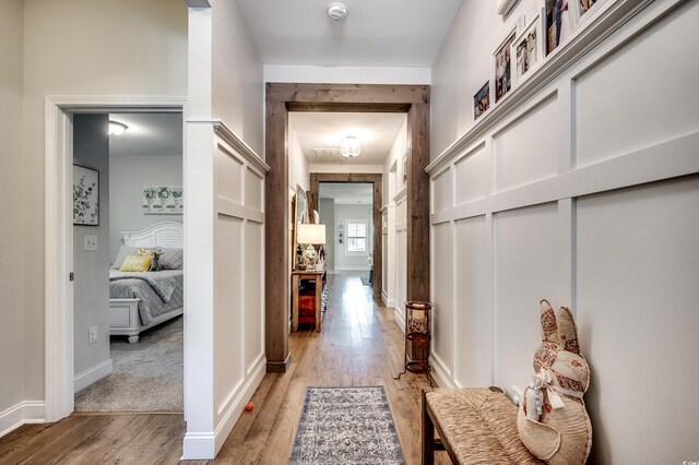 corridor featuring light wood-style flooring and baseboards