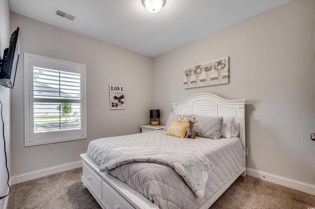 bedroom with light colored carpet and baseboards