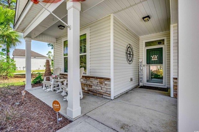 entrance to property with covered porch and stone siding